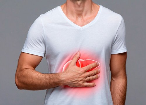 Больная печень у мужчины Мужчина держится за больное место